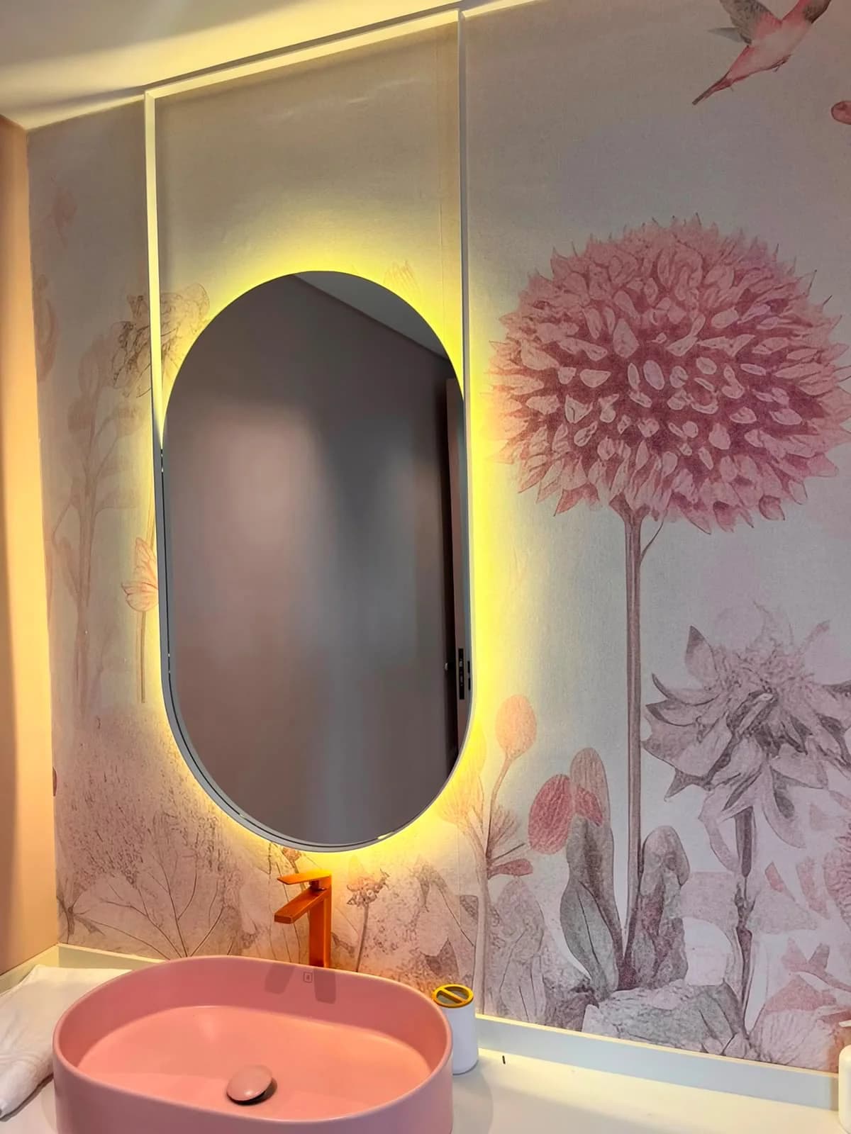 Espejo píldora con luz LED colgado en un baño